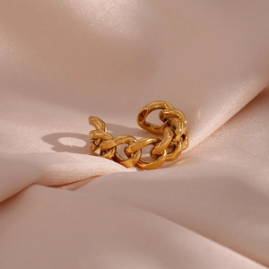 Macro detail of golden chain link ear cuff on pink silk background without piercing