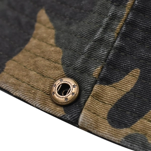 Macro view of jungle camo fabric with a bronze metal snap button featuring star engraving