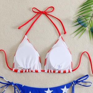 Detailed view of American flag bikini with star patterns and red halter ties on beige rug