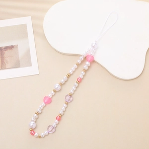 Detail of beaded phone strap with faux pearls and pink heart charms on white stand