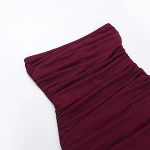 Vue détaillée du tissu froncé bordeaux montrant le design plissé élégant de la robe chic