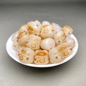 Makroansicht cremefarbener Bodhi-Wurzelperlen in Glückskatzenform für DIY-Schmuckherstellung