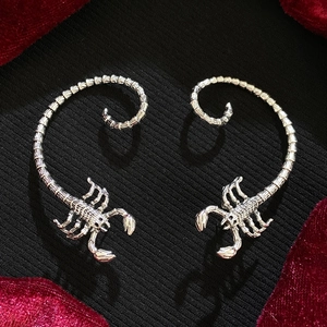 Gothic silver scorpion ear cuff with punk style on black fabric background