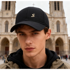 Close-up of black baseball cap featuring gold S Sports embroidery and curved brim