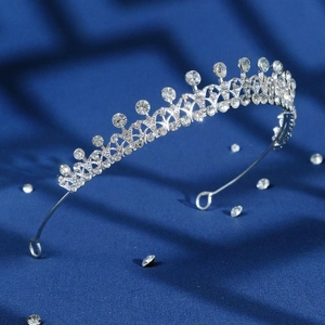 Baroque silver bridal crown with sparkling rhinestones on elegant dark blue silk backdrop