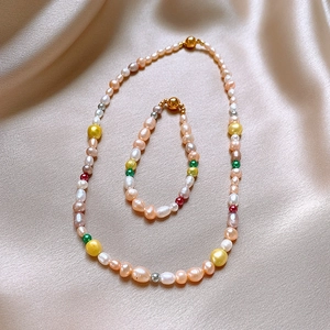 Détail du collier et bracelet en perles baroques sur tissu de soie beige élégant