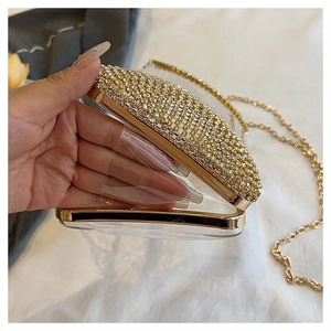Detail of transparent acrylic evening clutch with sparkling rhinestones and gold metal frame