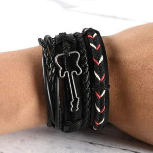 Close-up of stacked black leather bracelets featuring a metal guitar charm and braided ropes