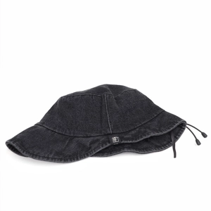 Detail of adjustable drawstring and logo tag on a black washed denim bucket hat