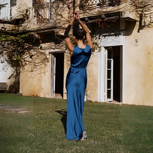 Détail de la robe de soirée en satin bleu foncé dos nu montrant le drapé élégant et fluide