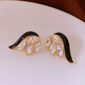 Vintage gold feather earrings with black enamel and marquise crystals for elegant fashion