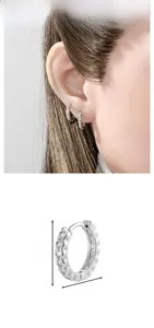 Detail showing dimension of silver hoop earrings with wavy texture and zircon stones