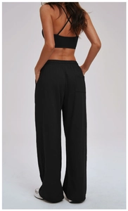 Detail view of high waist loose sports trousers and criss-cross back athletic bra in black
