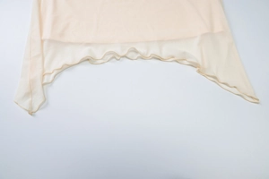 Detailed macro view of the sheer mesh fabric and irregular ruffle hemline on the skirt