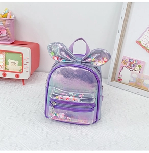 Detail of purple iridescent kids backpack featuring rabbit ears and sequins in a clear pocket