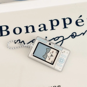 Detail of a retro mini game console acrylic keychain with a cute blue cat on a ceramic tray