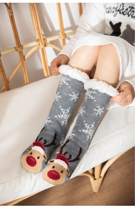 Détail de chaussettes de Noël grises avec motif renne et doublure pelucheuse blanche