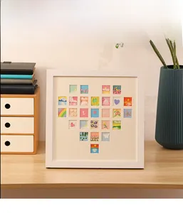 Detail of white square frame featuring a heart shape mosaic of 25 miniature oil paintings