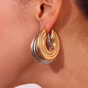 Exaggerated multi-layer gold and silver mixed hoop earrings on female model