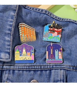 Detail of colorful Shanghai landmark enamel pins featuring Wukang Building on blue denim jacket