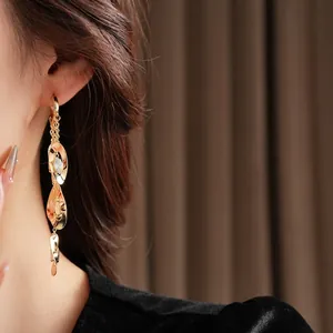 Boucles d'oreilles dorées avec zircon et pampilles en métal évidé pour un look élégant
