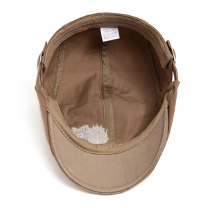 Detailed interior view of a brown 100% cotton flat cap showing the wash label