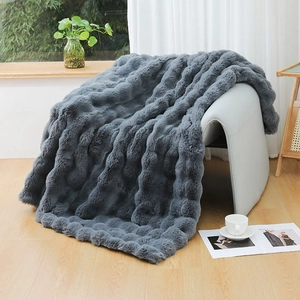 Detail of dark grey thick faux rabbit fur blanket with luxury 3D bubble texture on a chair