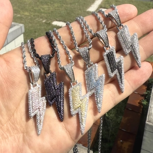 Gros plan de pendentifs éclair hip hop avec zircons et chaînes torsadées en extérieur