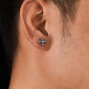 Retro punk style stainless steel cross stud earring shown on a model ear