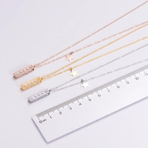 Detailed view of three crystal pendants in gold silver and rose gold with a centimeter ruler
