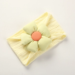 Macro detail of soft nylon baby headband with knitted flower in yellow and green