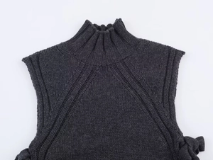 Macro detail of dark grey wool blend knit vest featuring a ribbed high neck collar