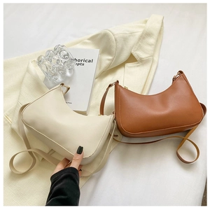 Chic beige and caramel brown half-moon underarm bags displayed on a neutral blazer