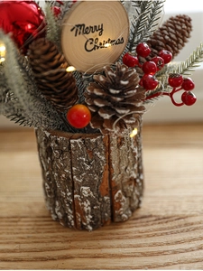 Close-up of Christmas centerpiece with pine cones, red berries and festive LED lights