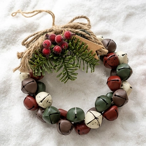 Christmas bell wreath with red, green bells, pine needles, and berries on white background