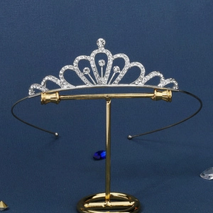 Detailed close-up of a silver bridal crown featuring wavy crystal-encrusted heart patterns
