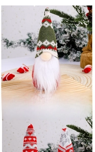 Close-up of a Christmas gnome doll with a snowflake knitted hat on a wooden tray