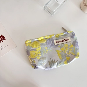Detail of French embossed floral pouch with silken texture and metallic zipper