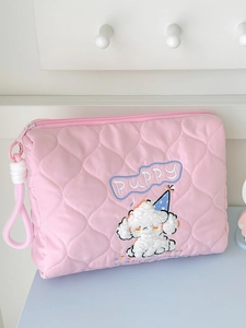 Close-up of pink quilted fabric texture and cute puppy embroidery on a storage bag