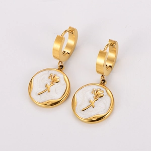 Close-up of gold earrings featuring white shell inlay and 3D rose flower detail