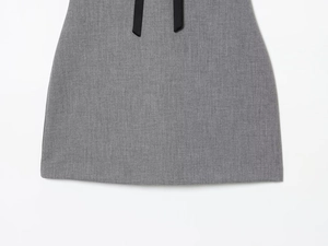Detail of grey satin dress with black decorative ribbons and soft texture finish