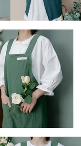 Detail of dark green washed linen apron with wide straps and vintage woven label