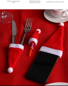 Detailed view of mini red Christmas hats for cutlery, phones, and lollipops decor