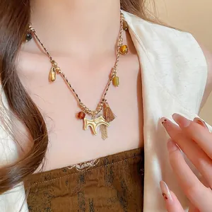 Bohemian braided cord necklace with a golden horse pendant and brown silk tassel