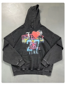 Detail eines Acid-Wash-Kapuzenpullovers mit Streetstyle-Grafikdruck auf grauem Grund