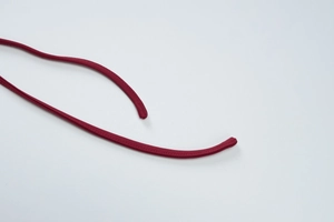 Detailed macro view of burgundy knit fabric texture and tidy stitching on a backless dress