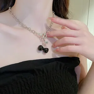 Edgy cherry pendant necklace with bold silver chain and OT toggle clasp on model
