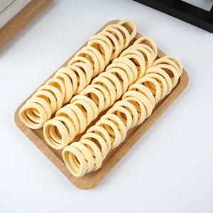 Detailed top view of bulk yellow elastic cotton hair ties neatly arranged on a wooden tray