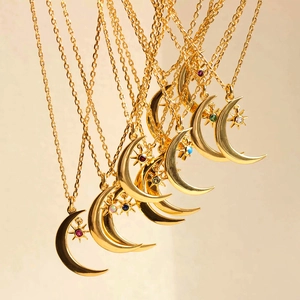 Detail of gold moon and star necklaces with colorful stones arranged in layers