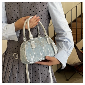 Close-up of blue denim Boston bag with silver sequins and metallic silver handles